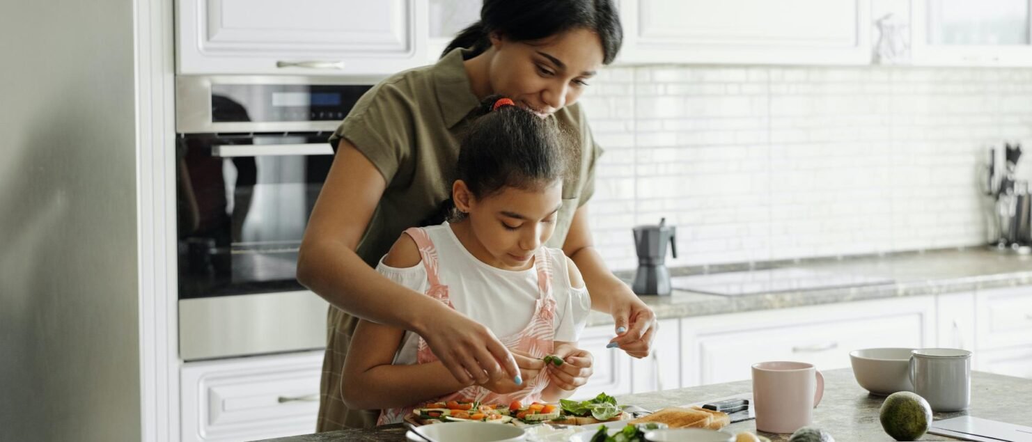 Mother teaching her young daughter to cook | Online fitness classes for kids in Bangalore