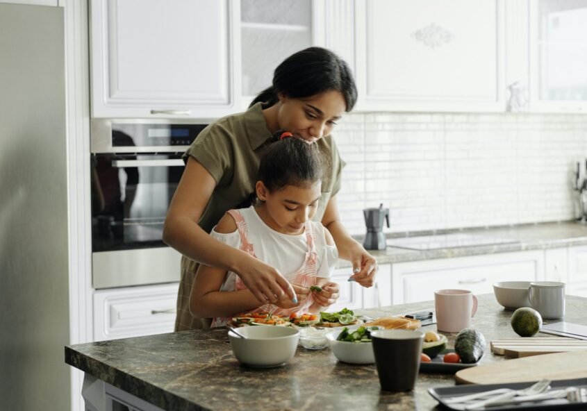 Mother teaching her young daughter to cook | Online fitness classes for kids in Bangalore